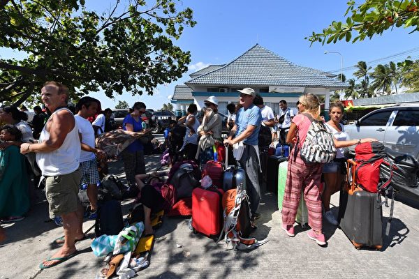 国外游客等待安排，离开龙目岛。 (Photo credit should read ADEK BERRY/AFP/Getty Images)